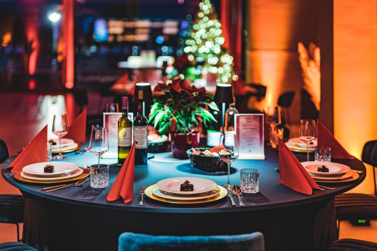Weihnachtlich geschmückter Festsaal im LAKESIDE mit gedecktem Banketttisch im Vordergrund und Weihnachtsbaum im Hintergrund.