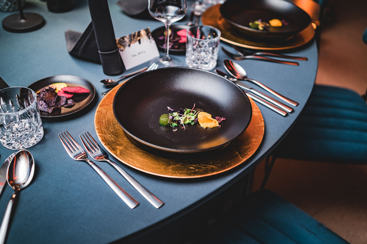 Hochwertiges Catering: Teller mit feinen Vorspeisen auf festlich gedecktem Tisch